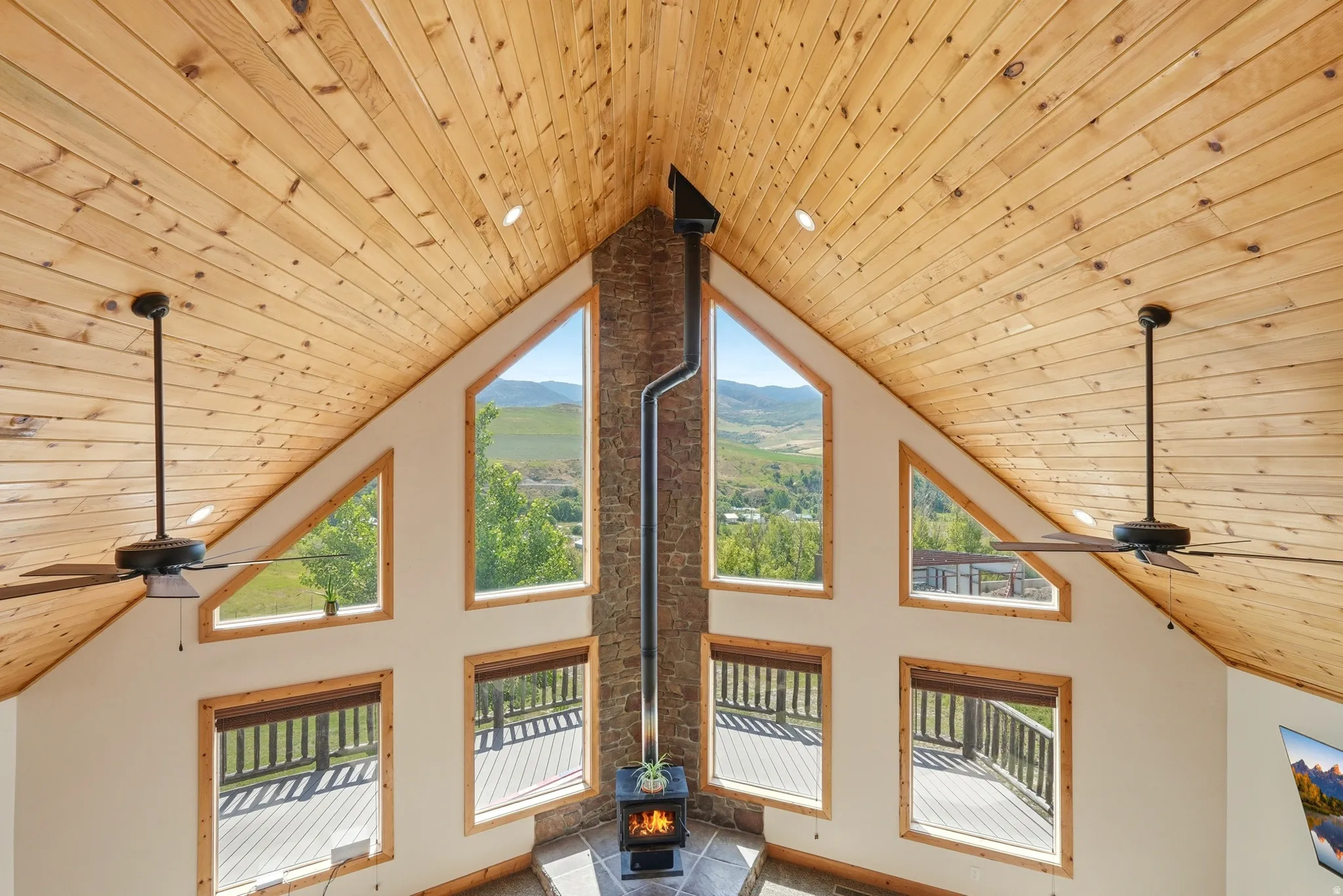 Vaulted wood-paneled ceiling with recessed lighting and ceiling fans