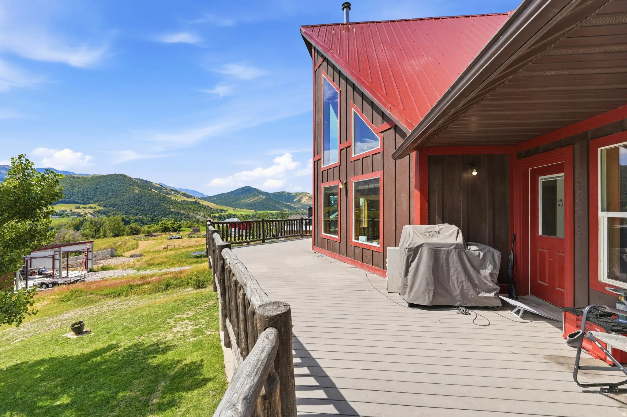 Expansive exterior deck featuring durable composite decking and a rustic log railing system