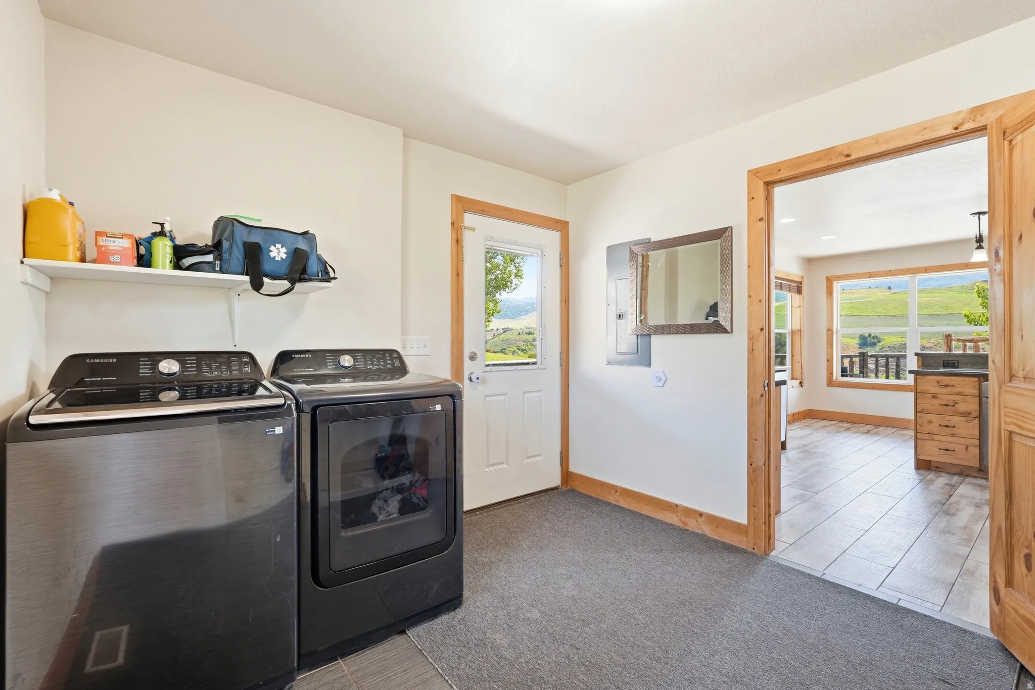 Dedicated laundry area with a white shelving unit, light-colored walls, and wood-trim doorways