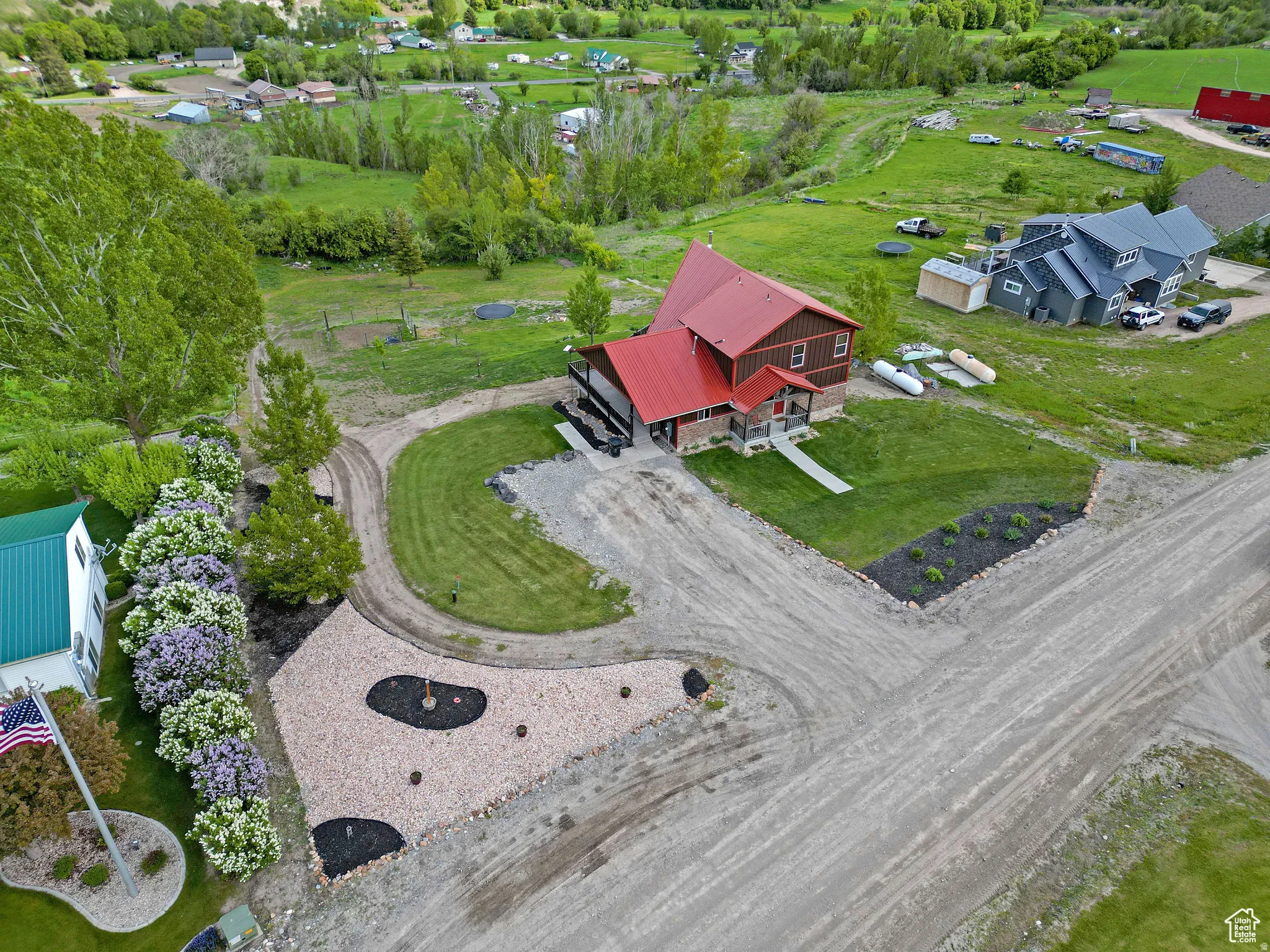 Two-story residence featuring a red metal roof and wood siding
