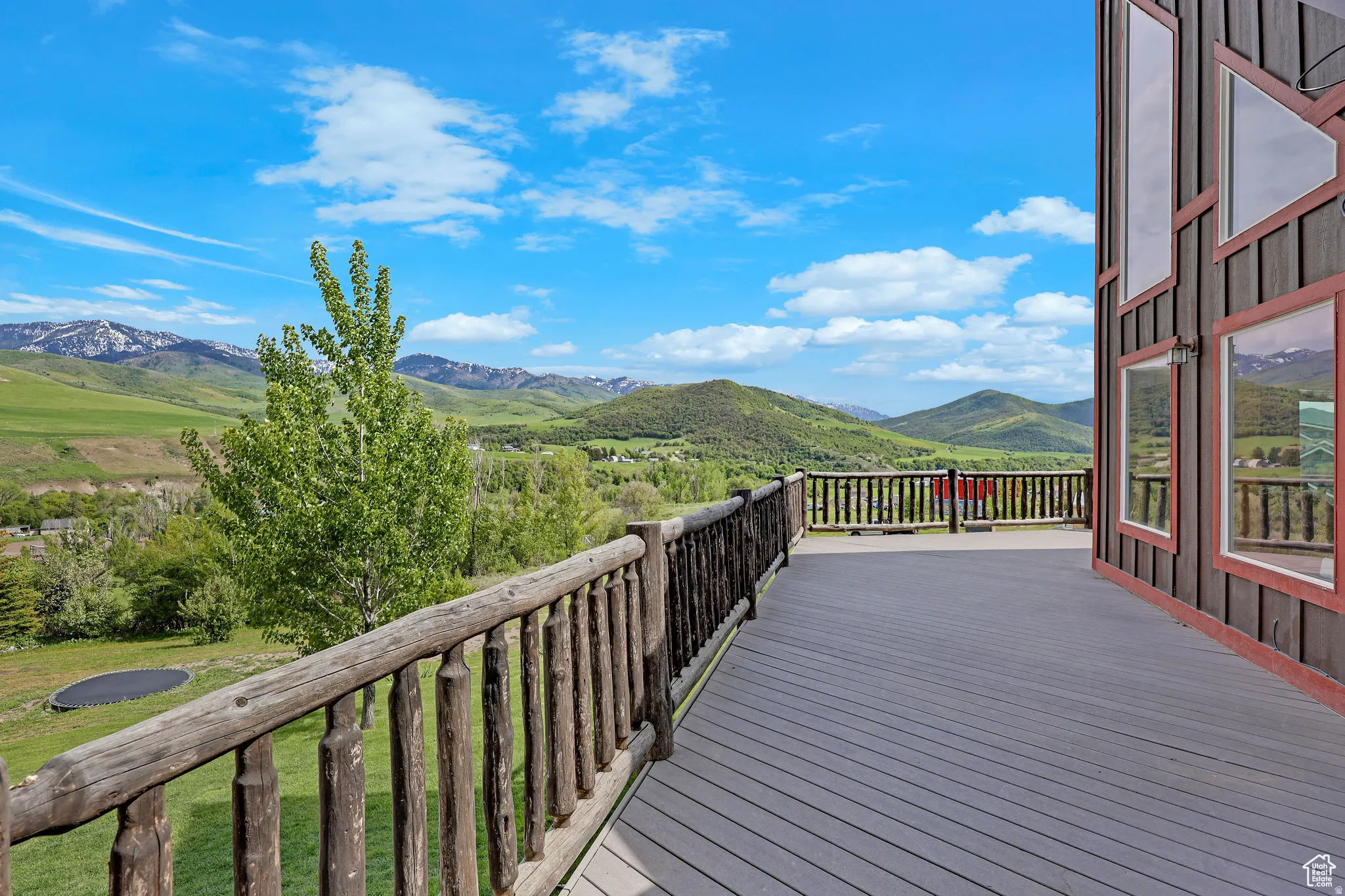 Expansive outdoor deck featuring composite decking and a rustic log railing
