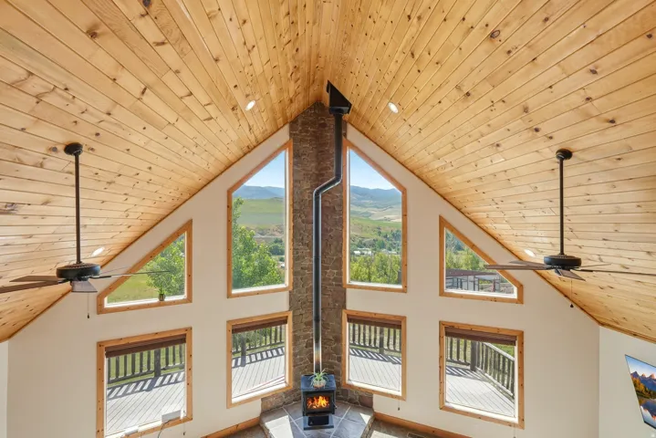 Vaulted wood-paneled ceiling with recessed lighting and ceiling fans