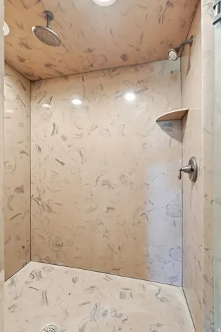 Walk-in shower with swirled wall and floor finishes