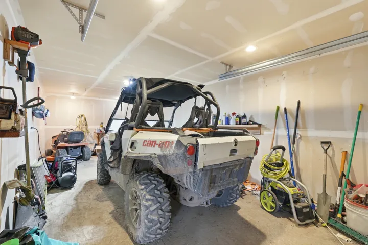 Spacious garage featuring exposed drywall walls and a concrete floor