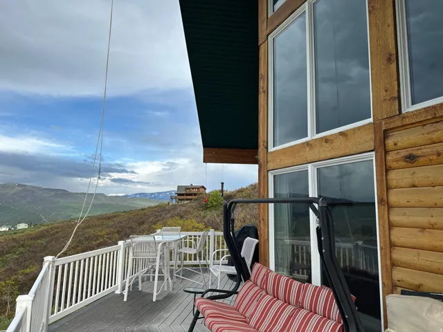 Spacious outdoor deck with white railing, composite decking, and mountain scenery