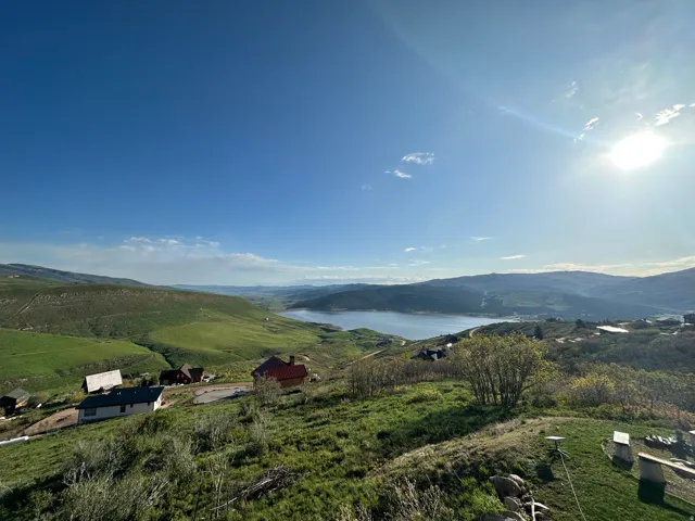 Expansive hillside property with distant mountain ranges and a prominent reservoir
