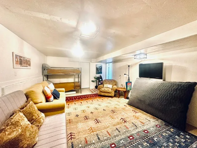 Recreational room featuring a mounted television, square ceiling light fixtures, and white painted walls