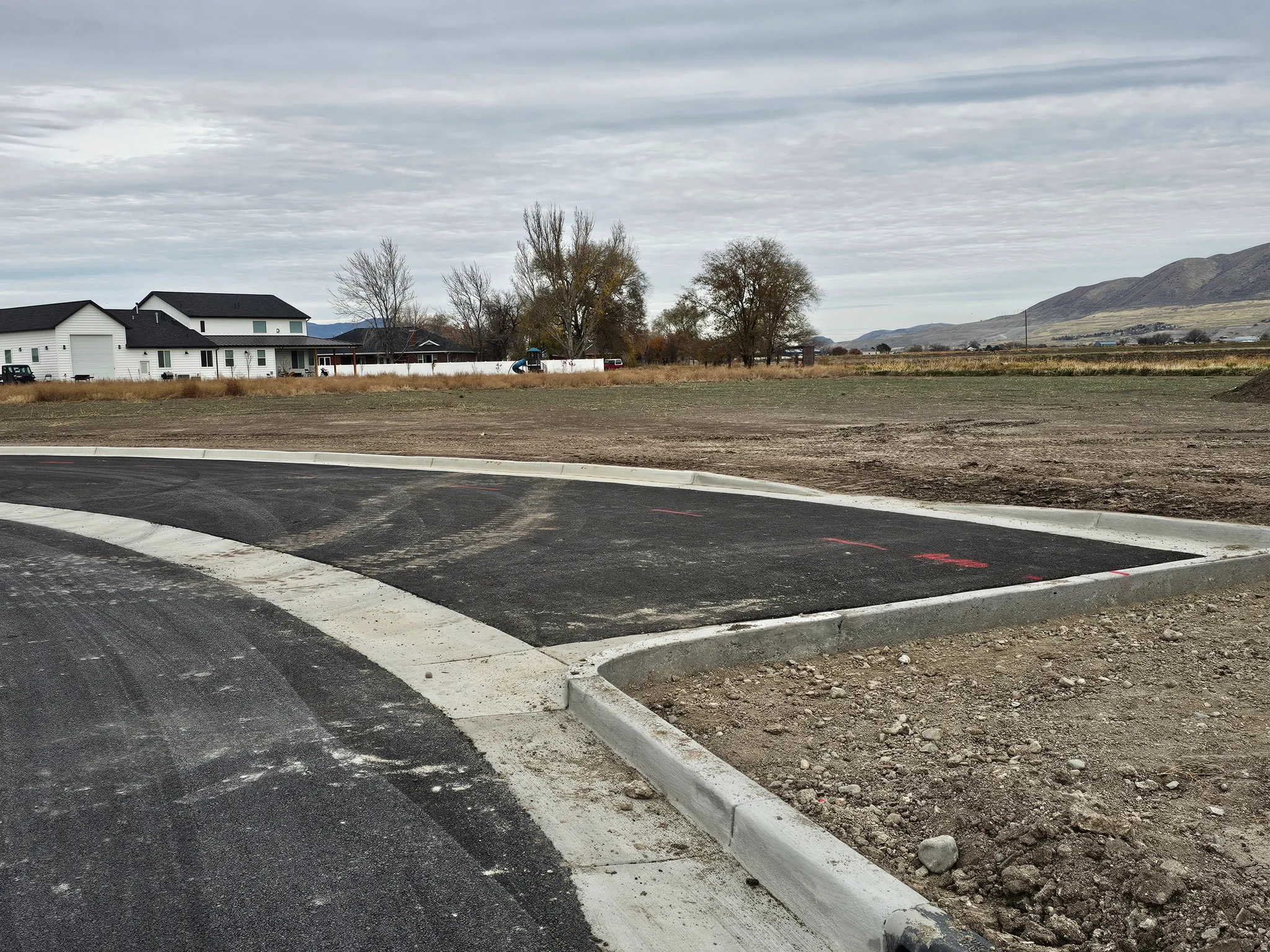 Newly paved asphalt road and concrete curb work