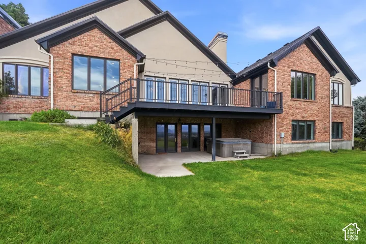 Exterior brick and stucco facade featuring a second-story deck with dark railings