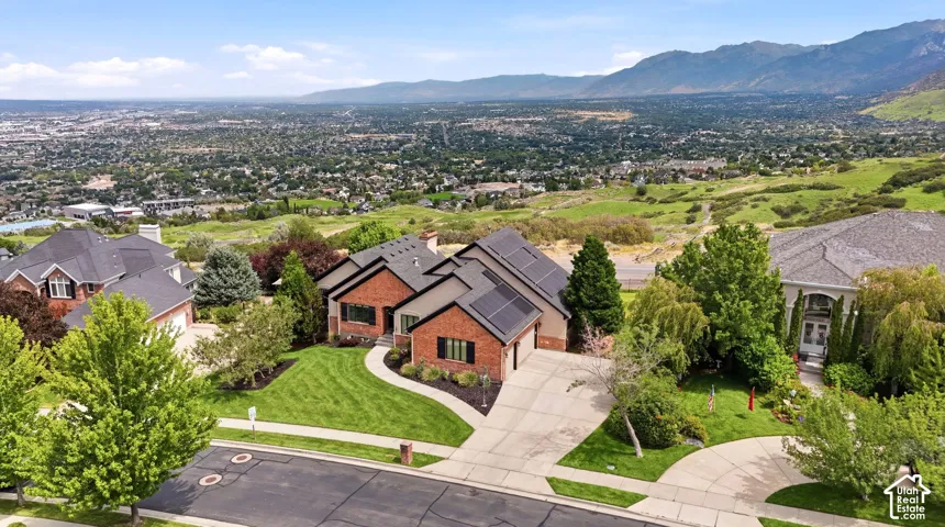 Brick residence with a multi-gabled roofline, concrete driveway, and solar panels