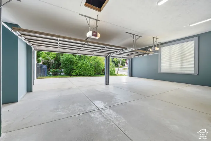 Spacious two-car garage with concrete flooring and teal-painted walls