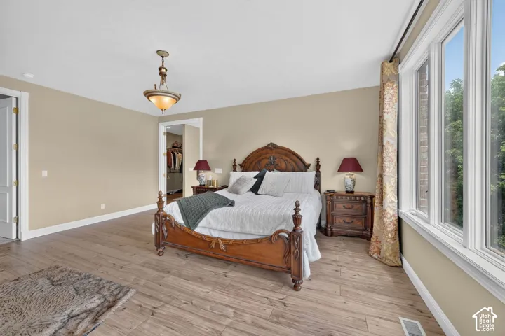 Spacious bedroom featuring wood-finish flooring and a neutral color palette