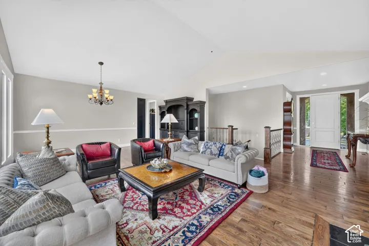 Spacious living area featuring wood-finish flooring, a decorative chandelier, and a built-in display cabinet