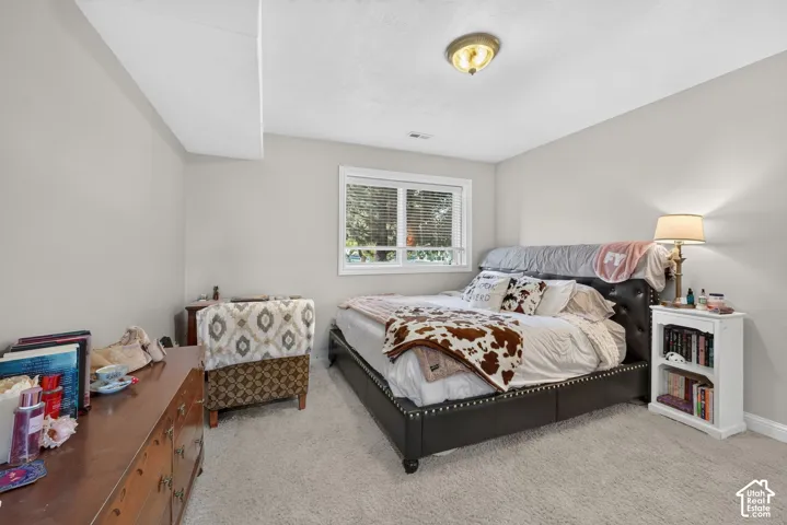 Carpeted bedroom featuring neutral wall tones and a single window with blinds