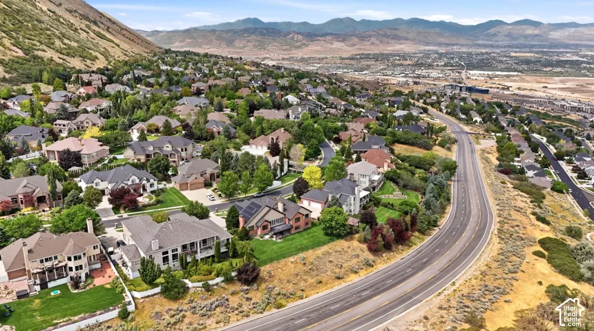Expansive residential area featuring numerous properties with varied architectural styles, mature landscaping, and an adjacent multi-lane paved road