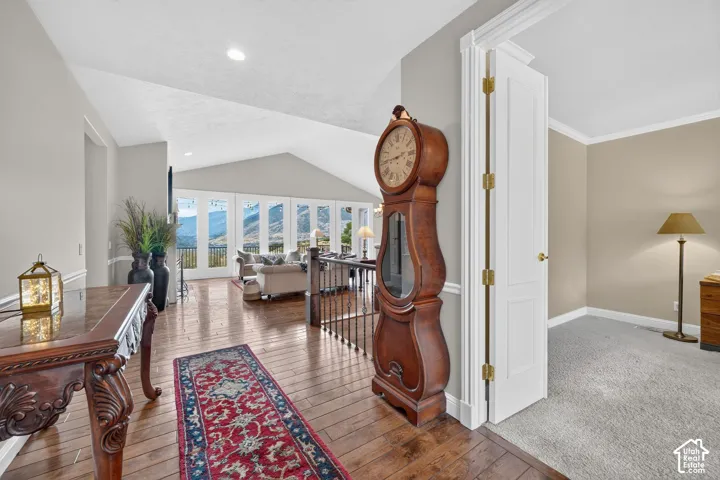 Hardwood-finish flooring extending into a spacious living area with vaulted ceilings and a wall of windows