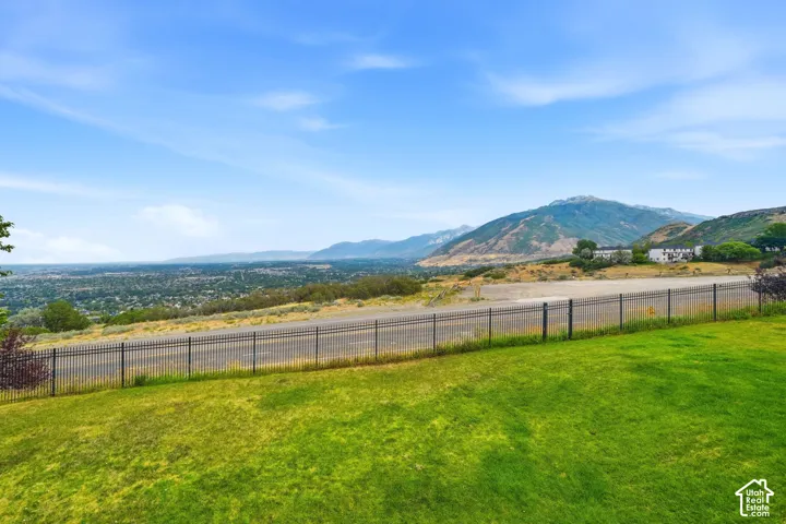 Expansive grassy lawn bordered by a metal fence