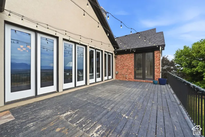 Expansive exterior deck featuring a dark wood finish and black metal railing