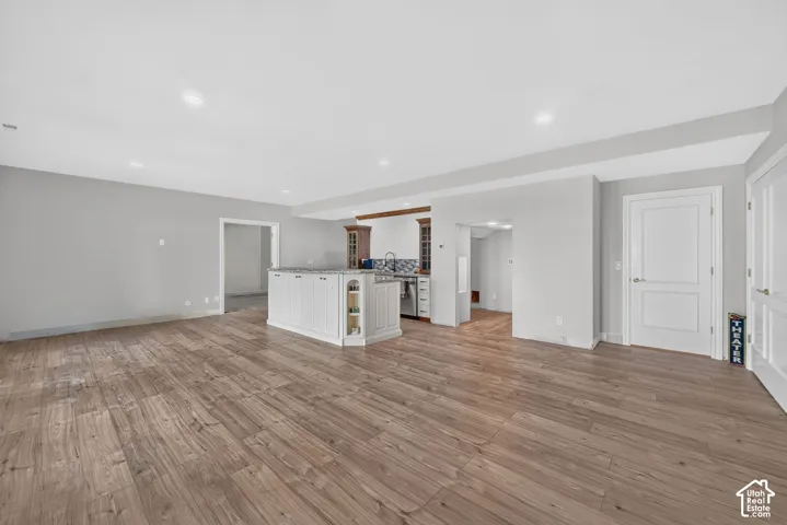 Spacious open-concept area featuring wood-finish flooring, recessed lighting, and light gray wall tones