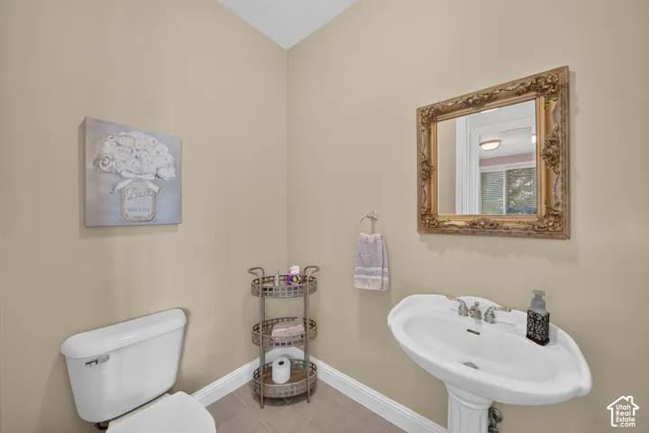 Pedestal sink with chrome-finish faucet, framed mirror, and light tan wall color
