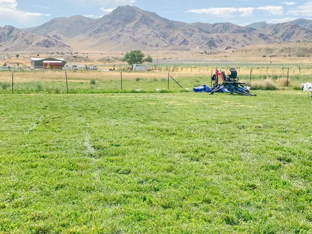 Expansive green parcel offering ample open space, perimeter fencing, and distant mountain scenery