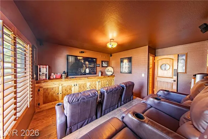 Dedicated media room featuring wood-finish flooring and a built-in entertainment console