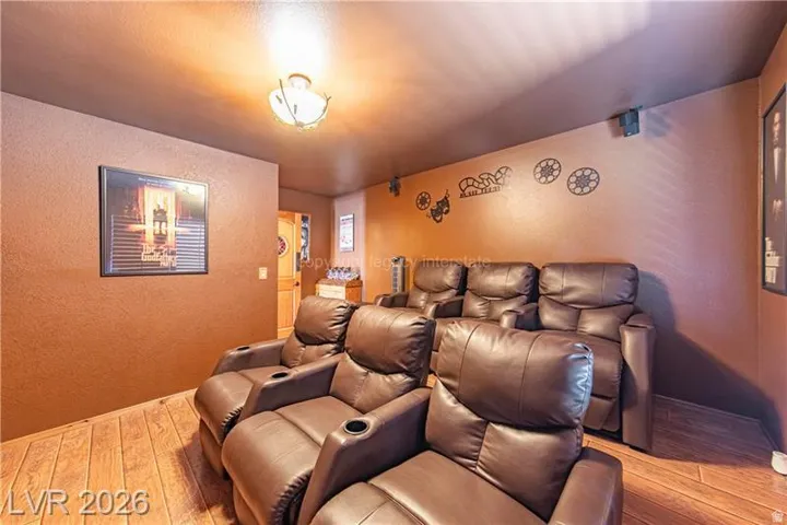 Dedicated media room featuring wood-finish flooring and a ceiling-mounted light fixture