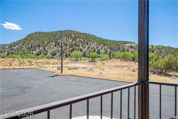 Expansive paved area framed by a metal railing and a wood-finish post