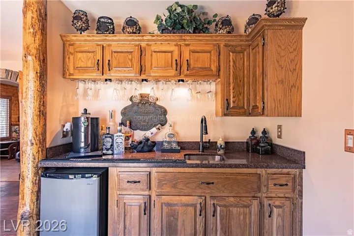 Built-in wet bar featuring a black sink, matte black faucet, and granite-style countertop