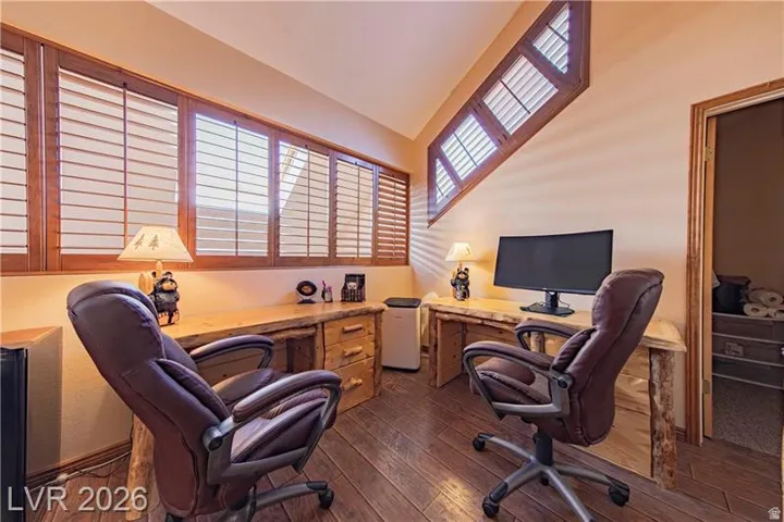 Wood-finish flooring throughout, complemented by two custom-built wooden desks with integrated drawers