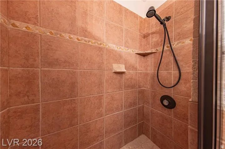Tiled shower enclosure featuring a decorative accent border