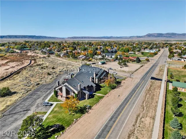 Multi-story property featuring a gabled roofline, multiple chimneys, and a stone facade accent