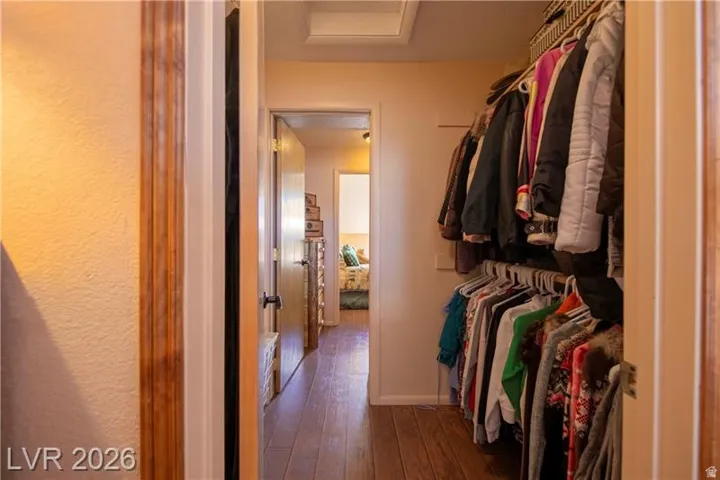 Hallway featuring wood-finish flooring, light-toned walls, and a recessed ceiling light