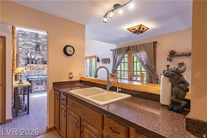 Kitchen area featuring wood-finish cabinetry, a dual basin sink, and speckle-patterned countertops