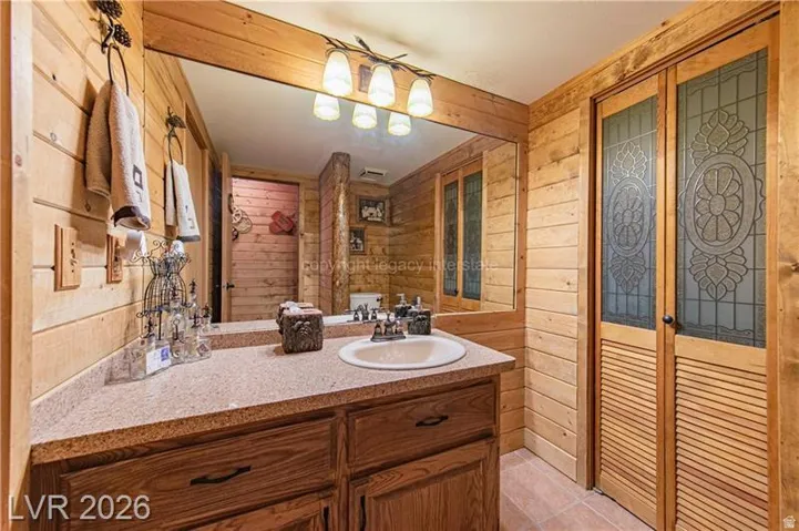 Bathroom vanity featuring a wood-finish cabinet, integrated sink, and speckled countertop