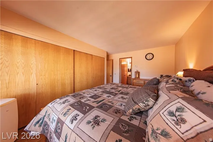 Spacious room featuring wood-finish sliding closet doors, neutral wall colors, and a ceiling-mounted light fixture