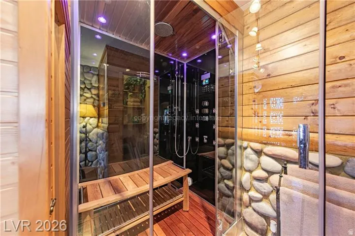 Custom shower enclosure featuring natural wood plank walls and ceiling