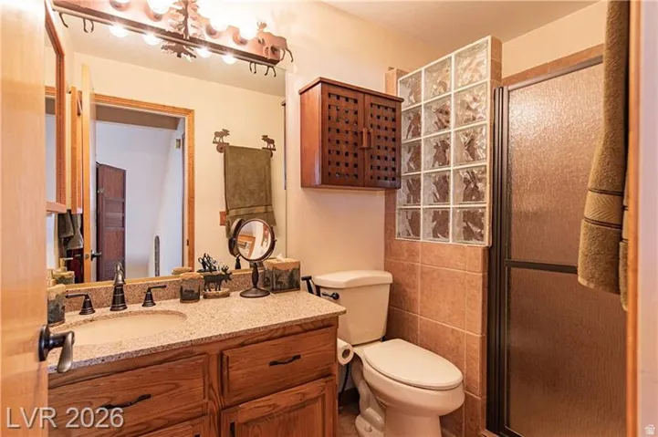 Bathroom featuring a wooden vanity with a speckled countertop and integrated sink