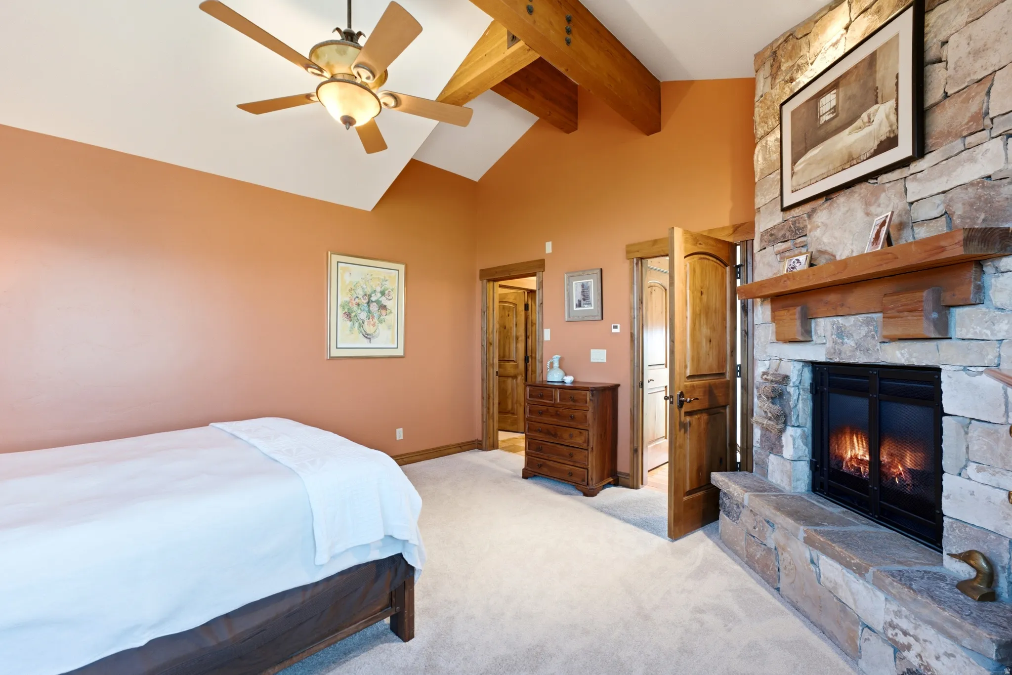 Vaulted ceiling with exposed wood beams and ceiling fan