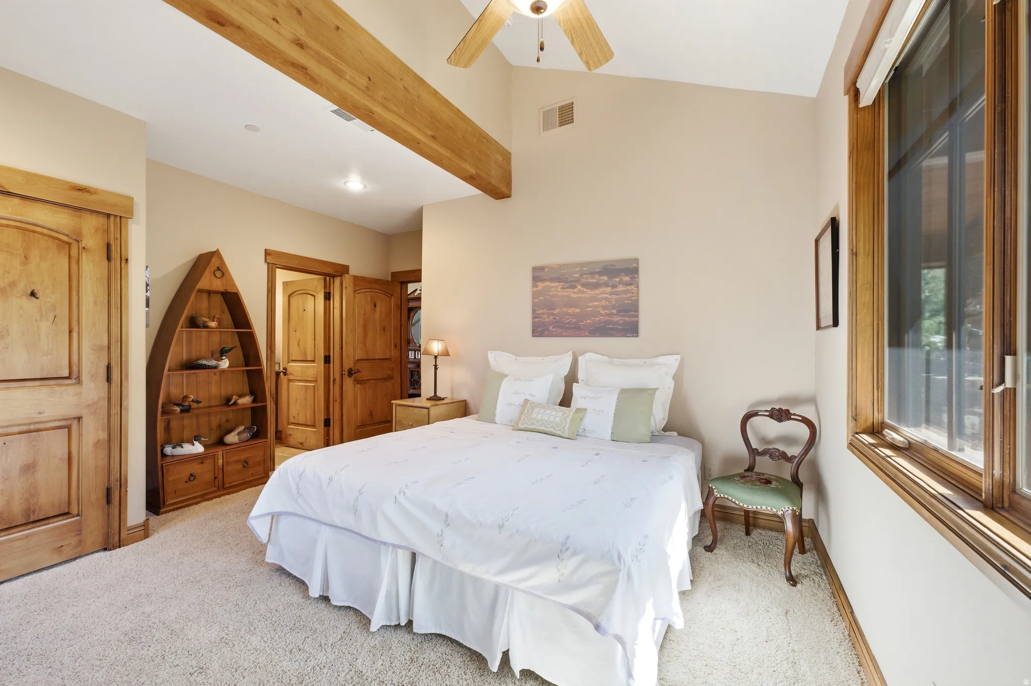 Guest Bedroom Vaulted ceiling with exposed wood beam and ceiling fan