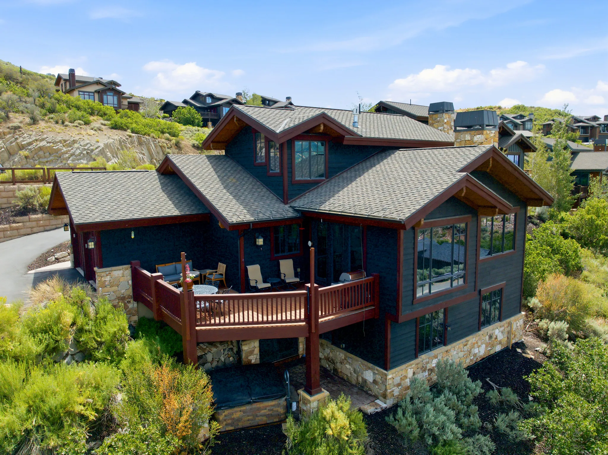 Multi-level residence featuring dark siding with stone accents