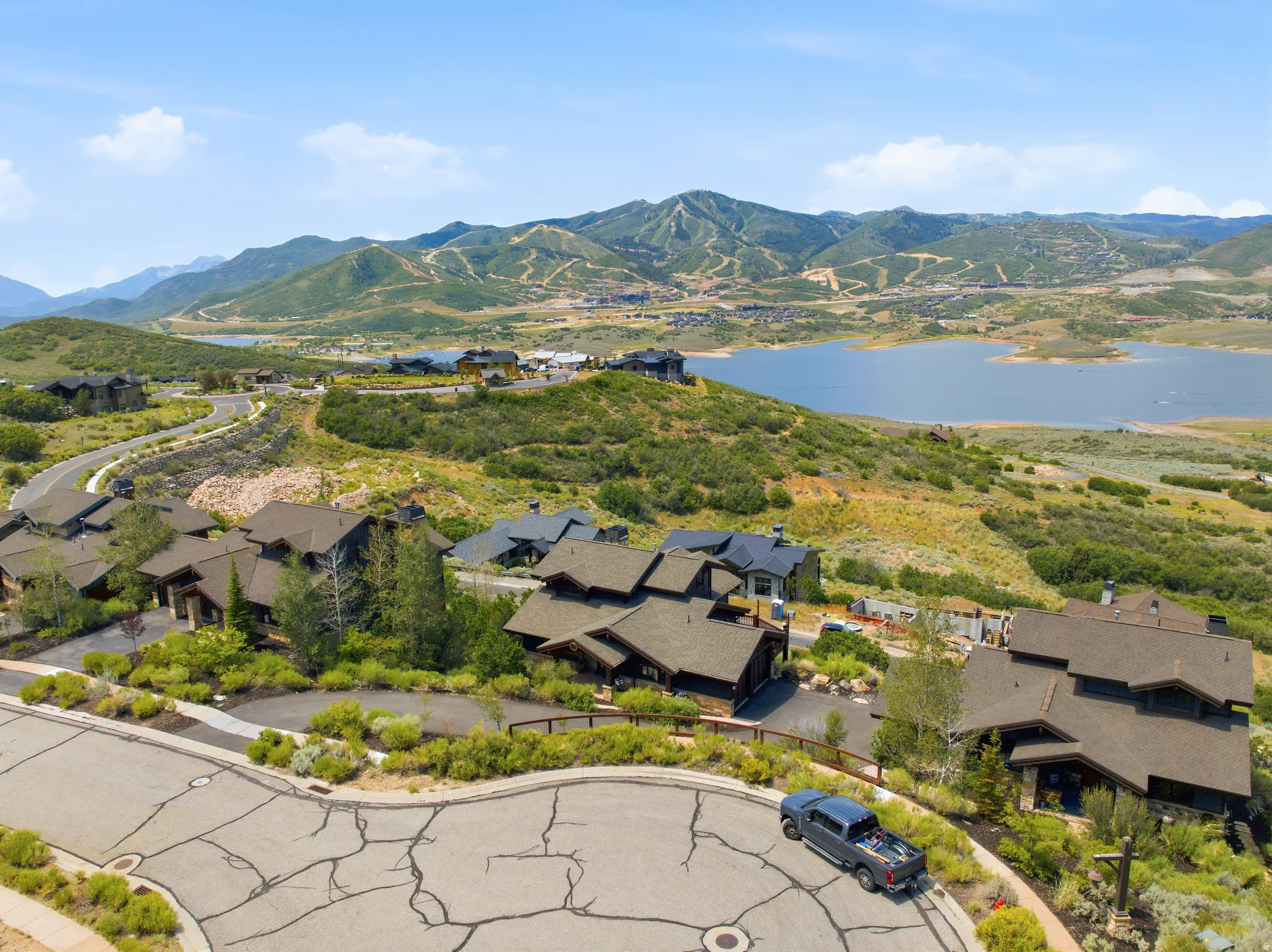 Expansive mountain landscape featuring a large body of water and distant ski slopes