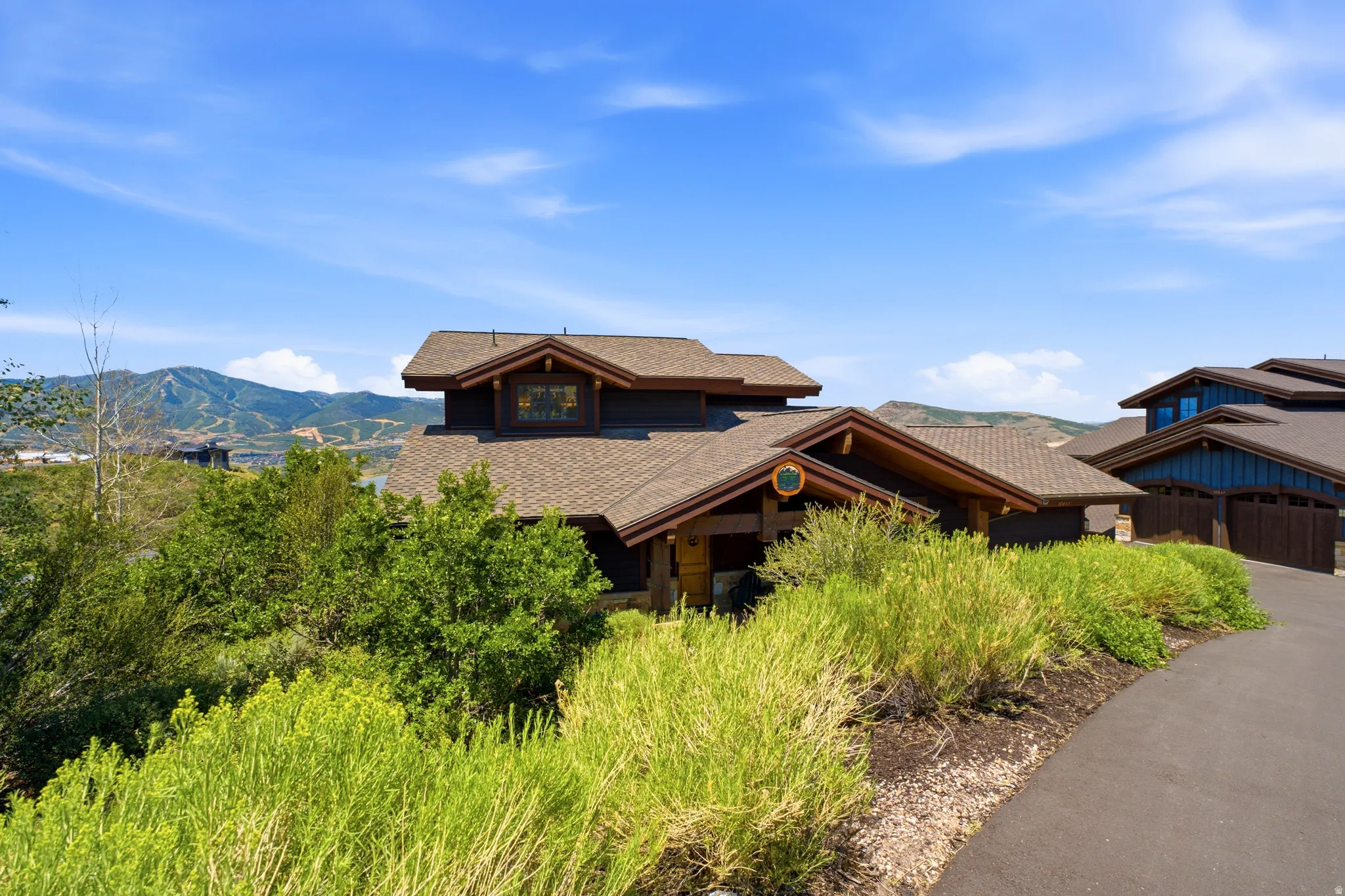 Mountain-style residence featuring a prominent gabled roofline, dark-toned siding, and natural wood accents