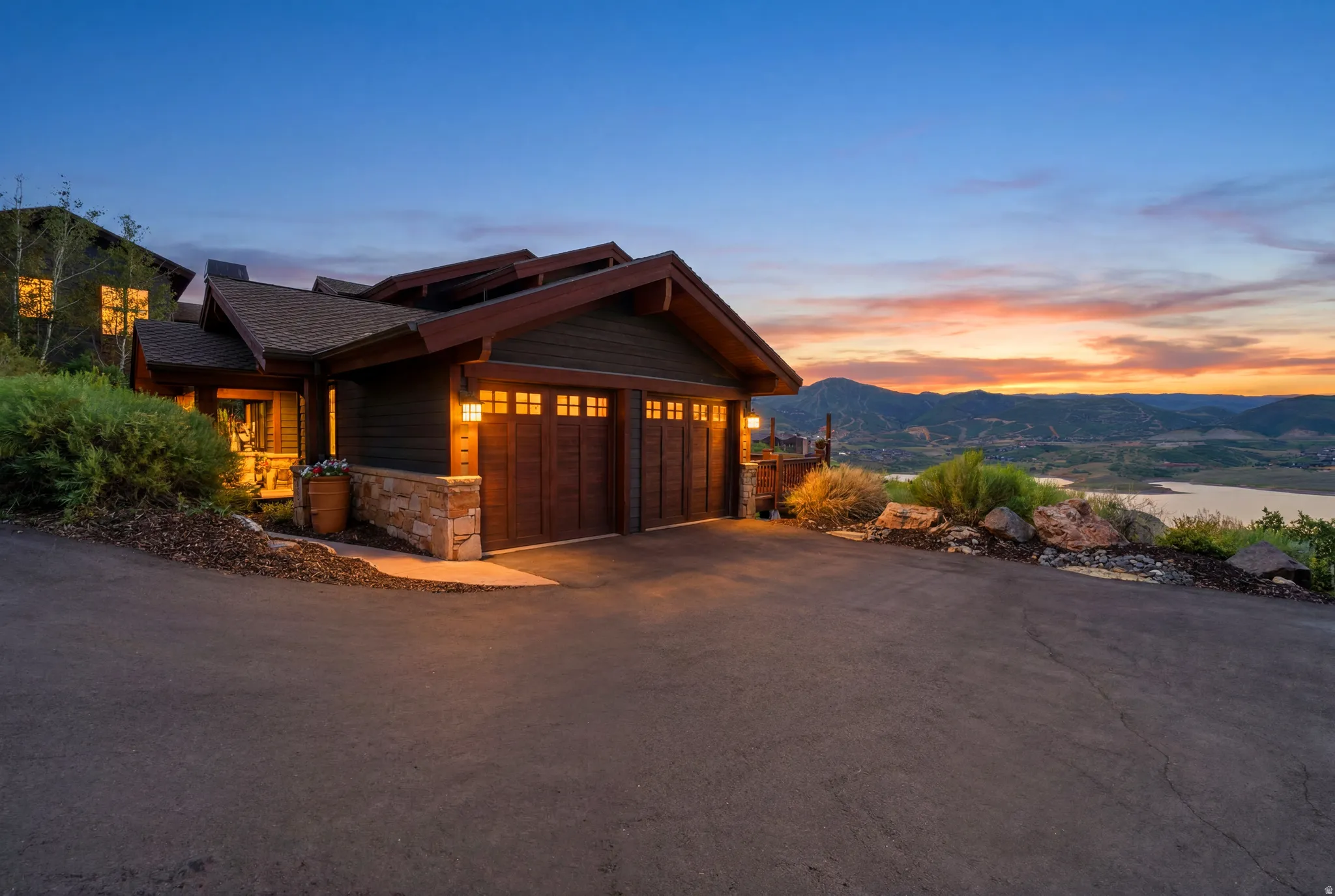 Craftsman-style exterior featuring a multi-car garage with wood-finish doors and transom windows