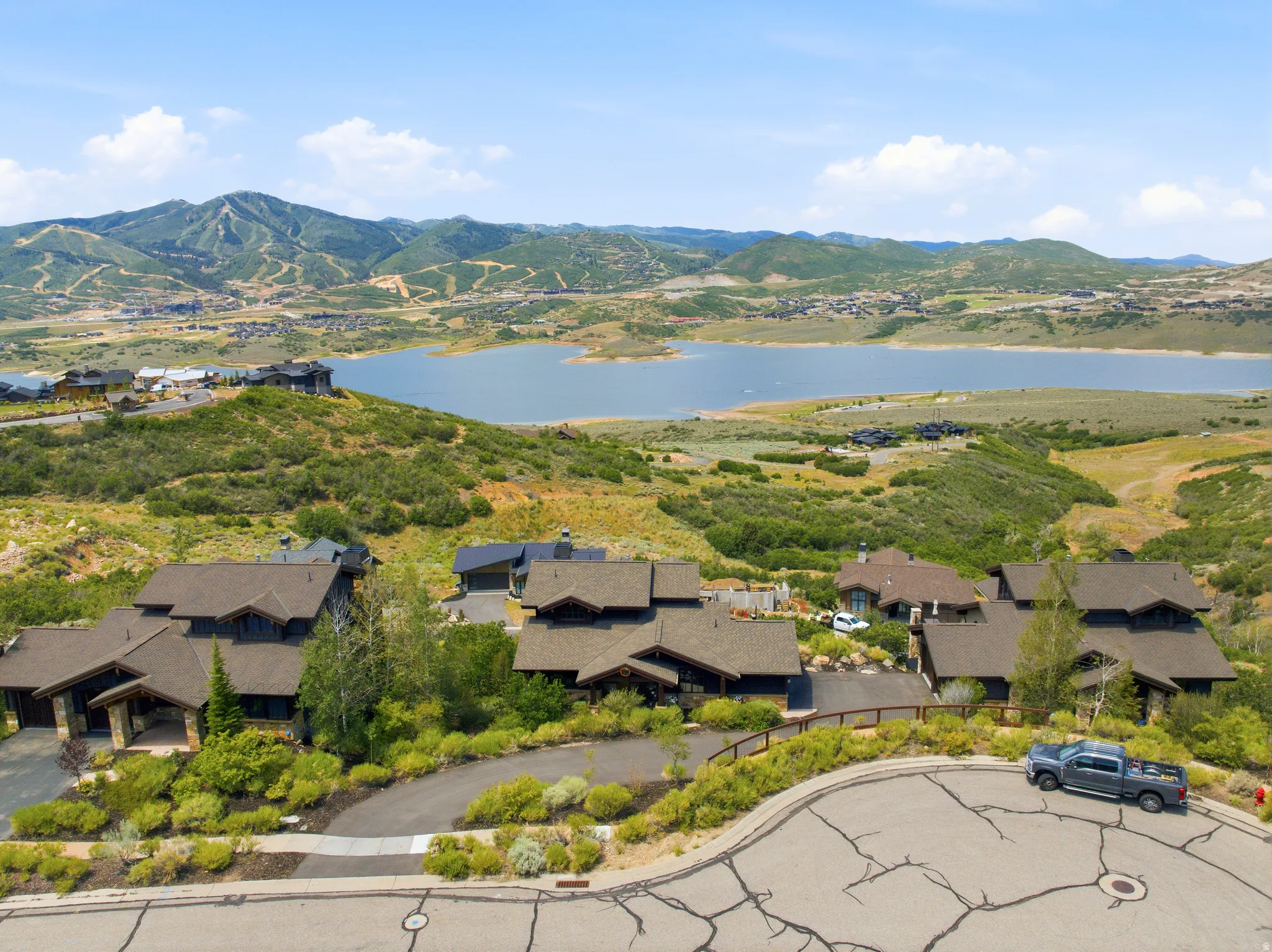 Scenic elevated properties featuring natural landscaping, dark-toned siding, and pitched roofs