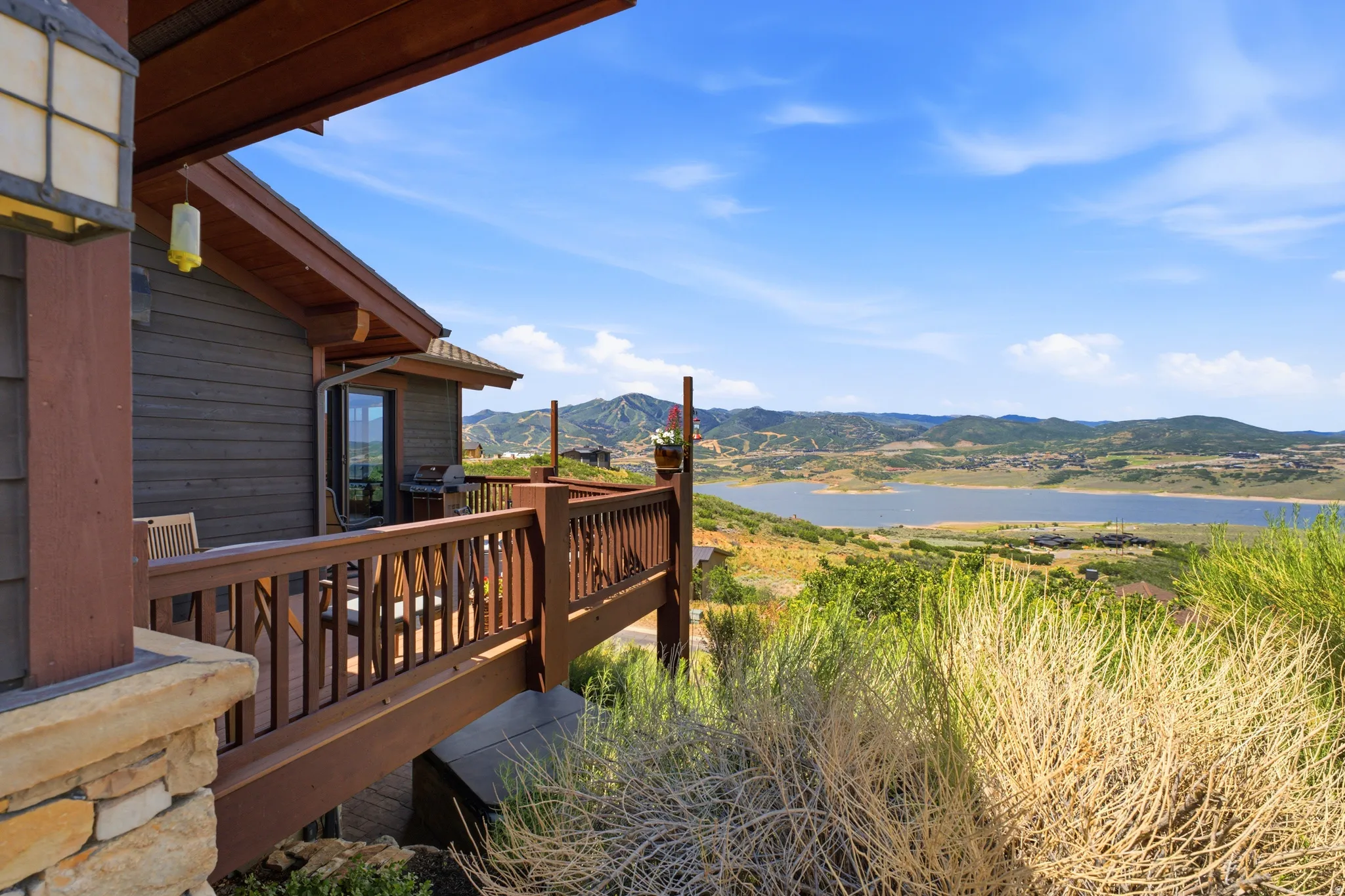 Expansive outdoor deck with wood railing and mountain lake scenery