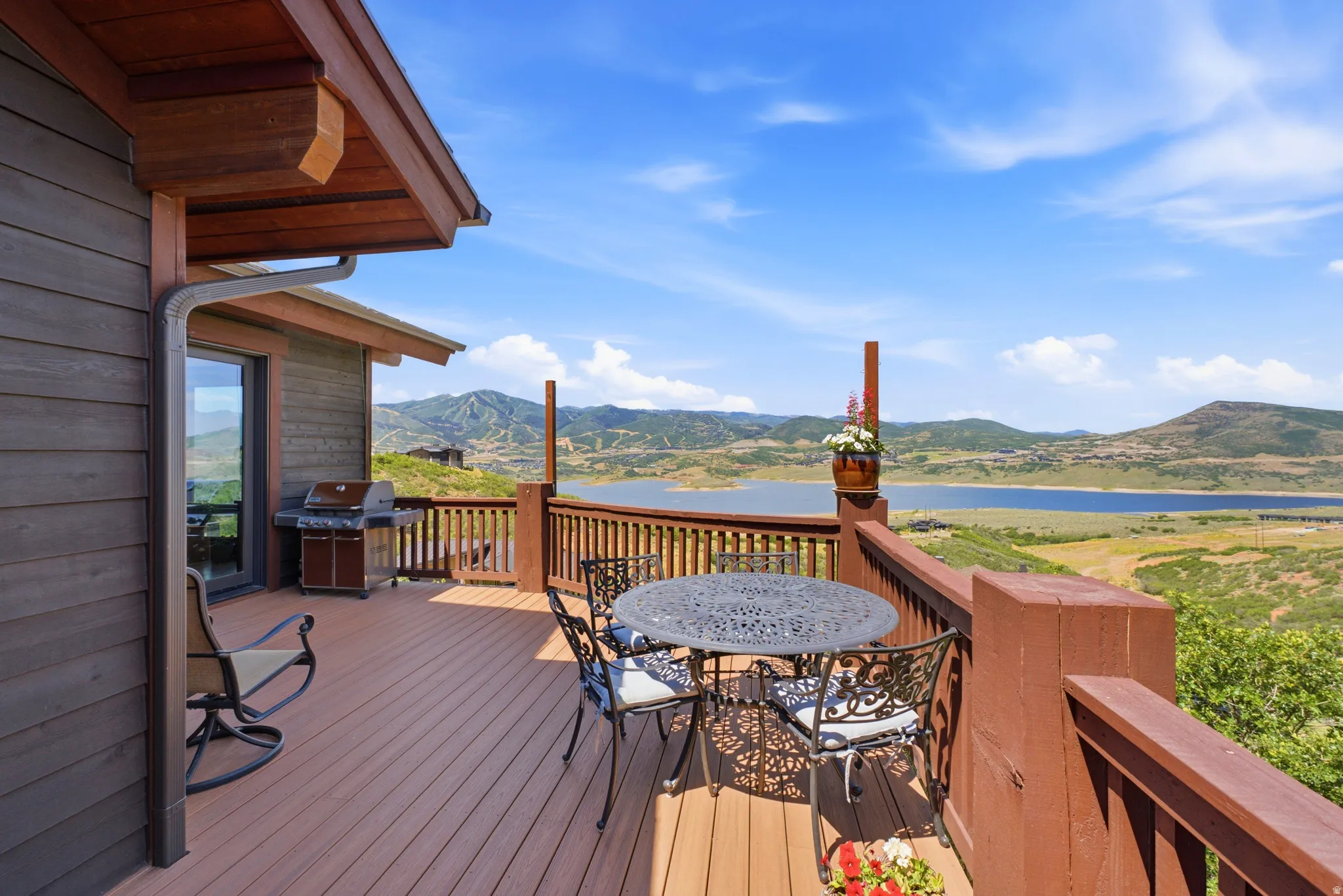 Spacious outdoor deck with composite decking, brown wood railings, and dark brown siding