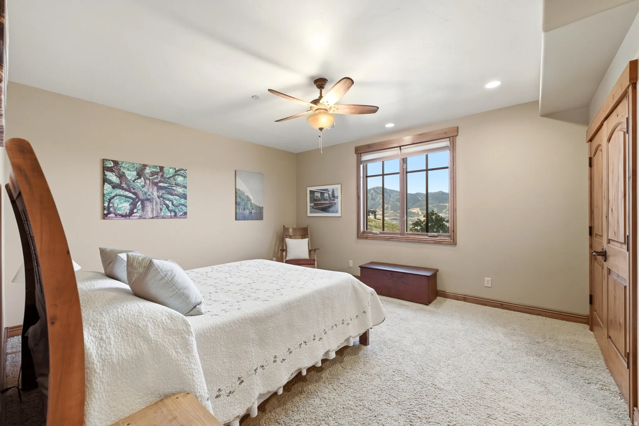 Carpeted room featuring a window with natural wood trim, showcasing a mountain backdrop