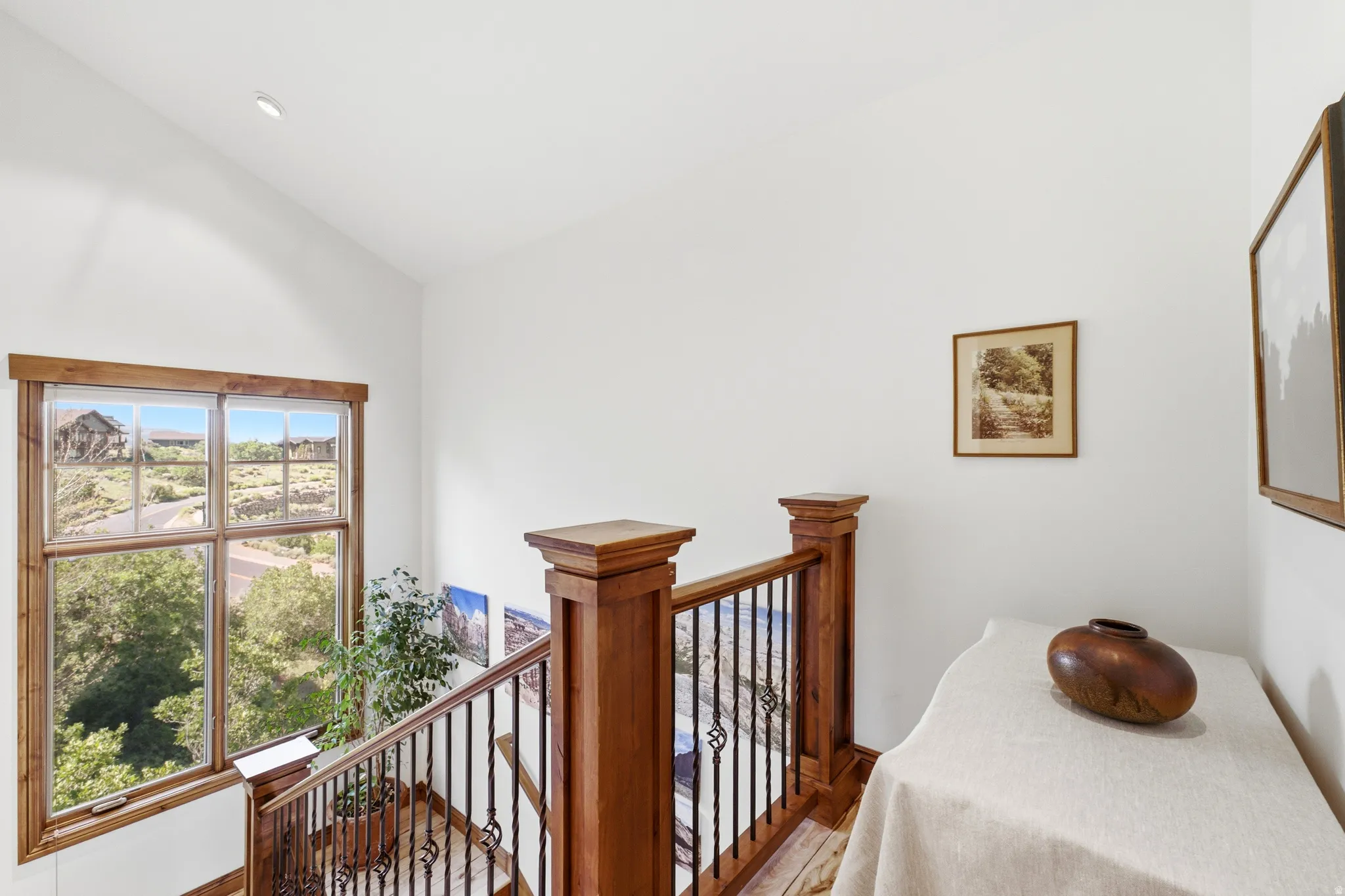 Staircase featuring wood-finish railings with wrought iron spindles