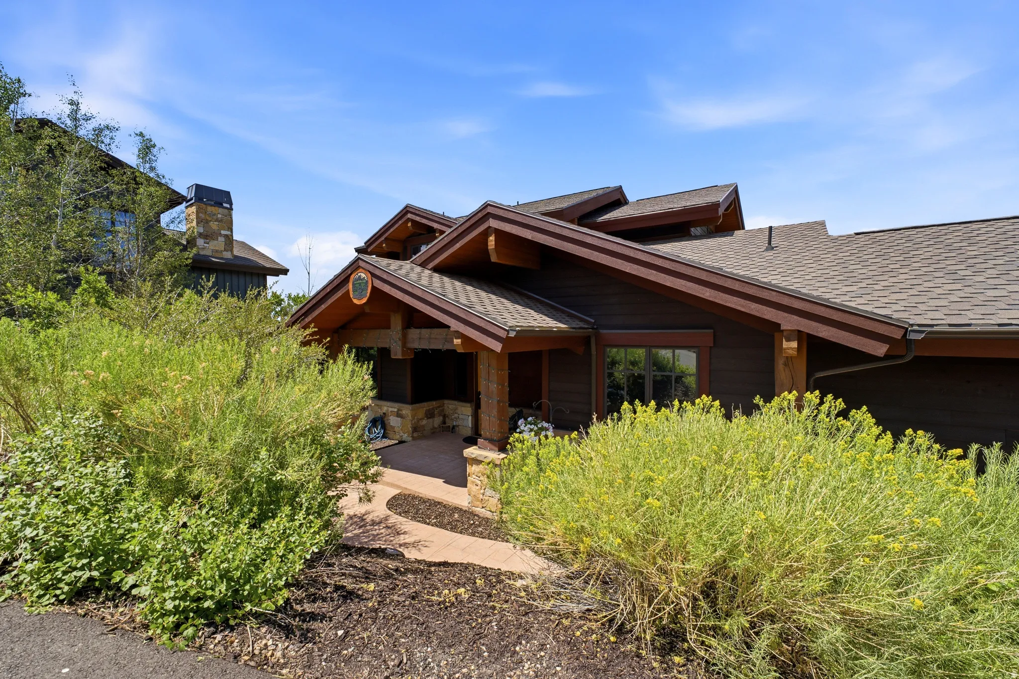 Brown shingled roofline over a dark wood-sided exterior